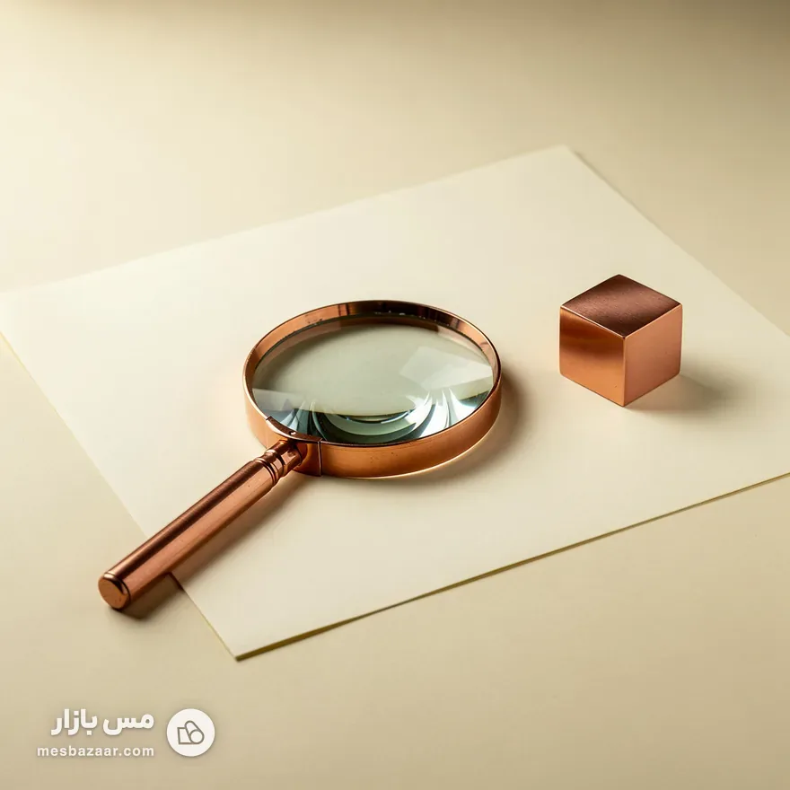 ذره‌بین با قاب مسی روی برگه‌ای سفید و مکعب مس — نماد واژه‌نامهٔ اصطلاحات بازار مس